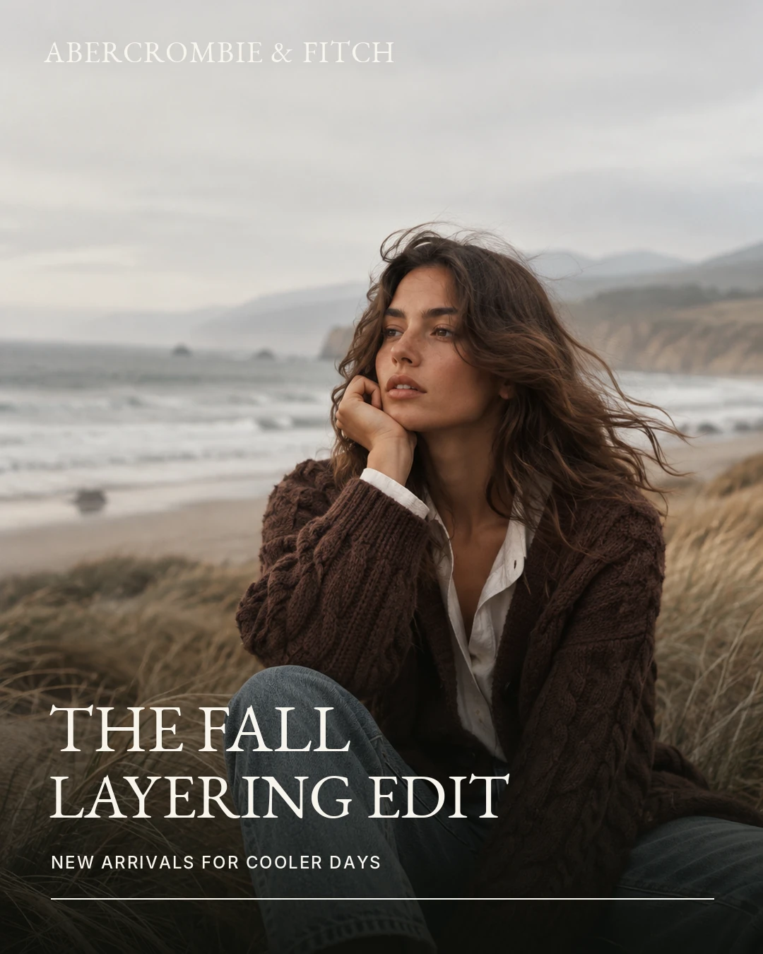 Paid social feed ad with a woman in a brown cardigan on a beach and the headline The Fall Layering Edit.